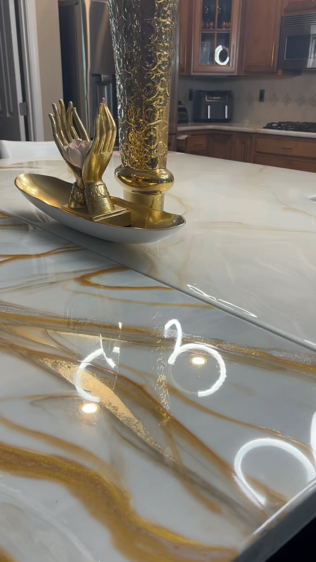 White and gold-veined epoxy island styled with gold ornaments, from the finished-project reel